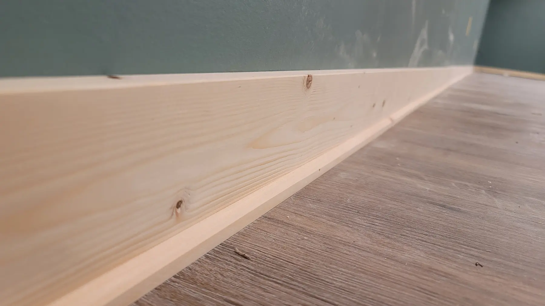Basement room with raw-wood box-beam columns and pine wainscot wall