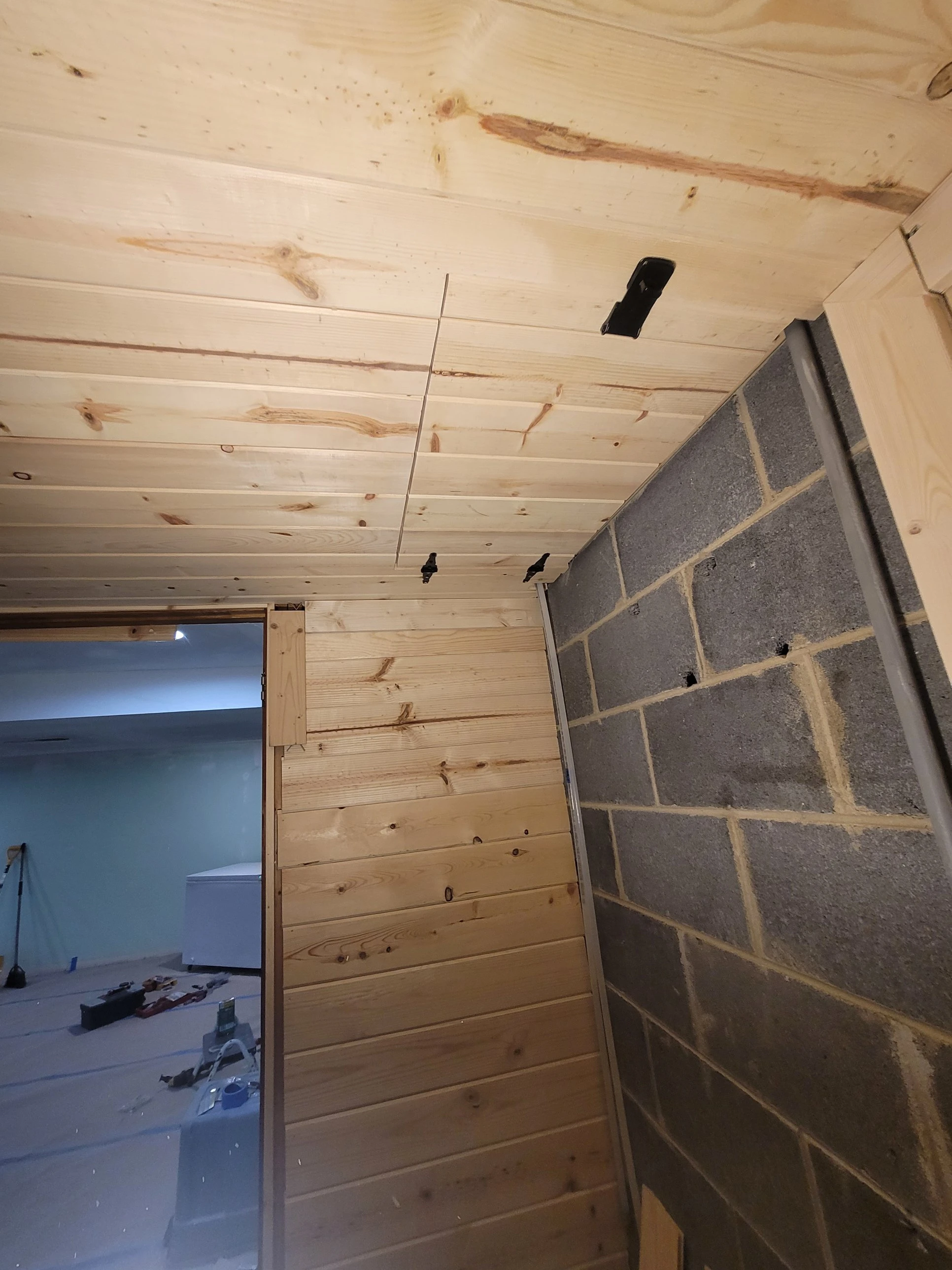 Access panel closed and flush in the utility nook ceiling, pine paneling finished on both sides